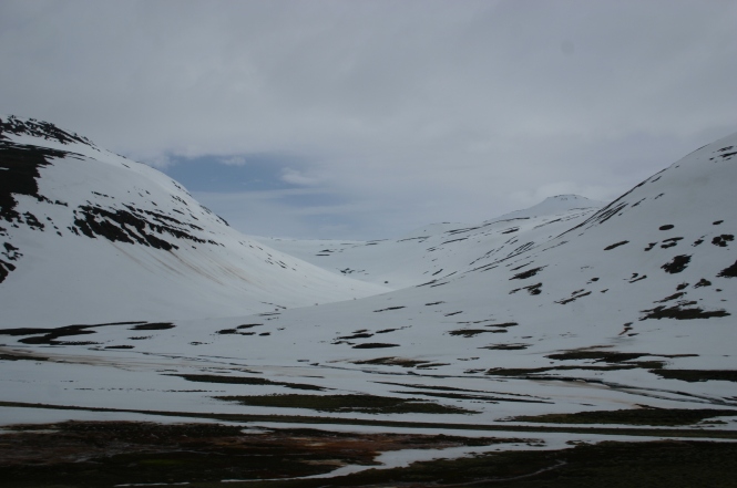 Drei leicht versetzt stehende schneebdeckte Bergspitzen.