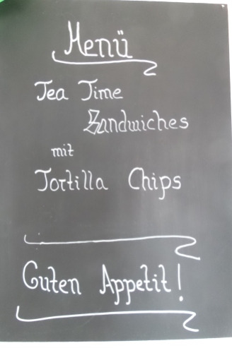 Tafel mit der Aufschrift: Menü - Tea Time Sandwiches mit Tortilla Chips - Guten Appetit!